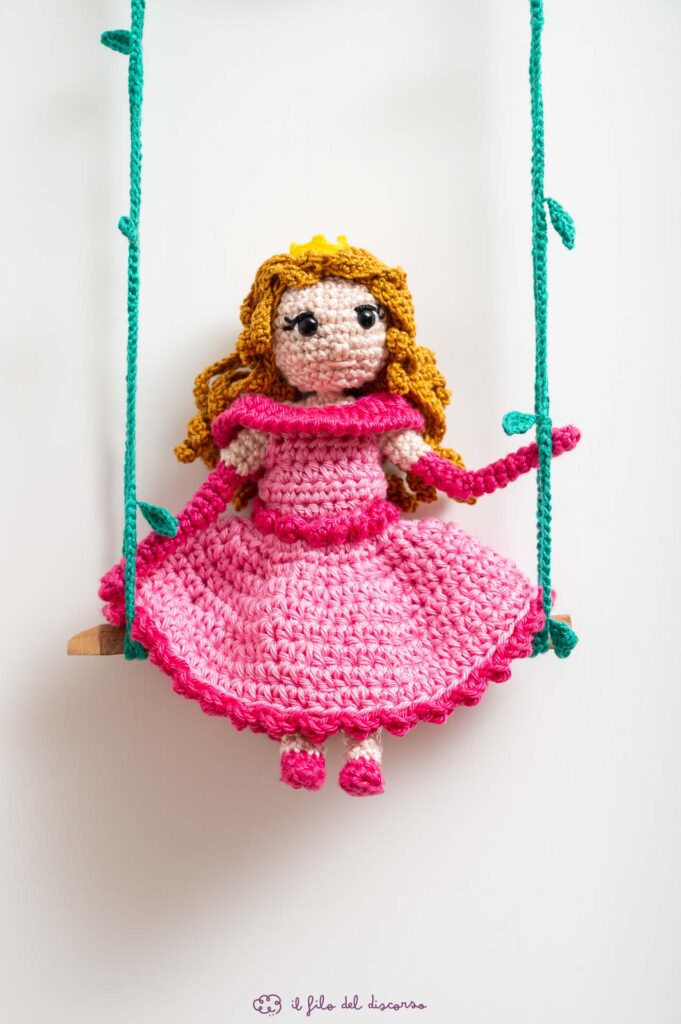 Creazione realizzata interamente a mano, all'uncinetto, per il primo compleanno di Elisa. Una principessa, realizzata in amigurumi, seduta su un'altalena appesa al suo nome, ed alla scritta in legno "il mio primo compleanno".